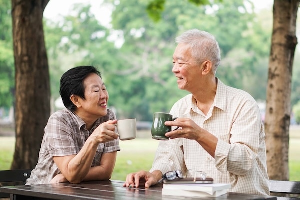 Elison Niles Independent Living | Senior korean couple relax drinking coffee in the park