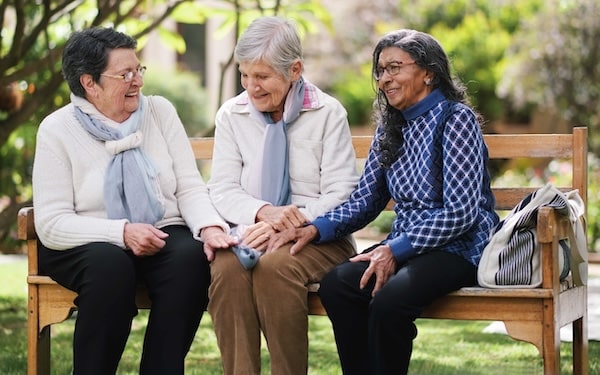 Elison Niles | Three senior friends sitting on a bench